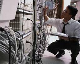 Technician working on network equipment rack